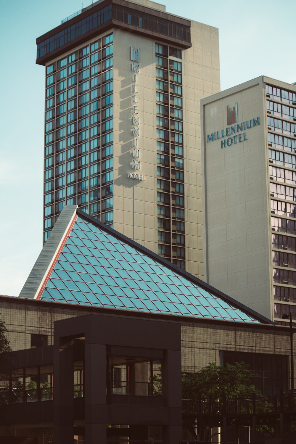 a tall building with a blue roof next to a tall building