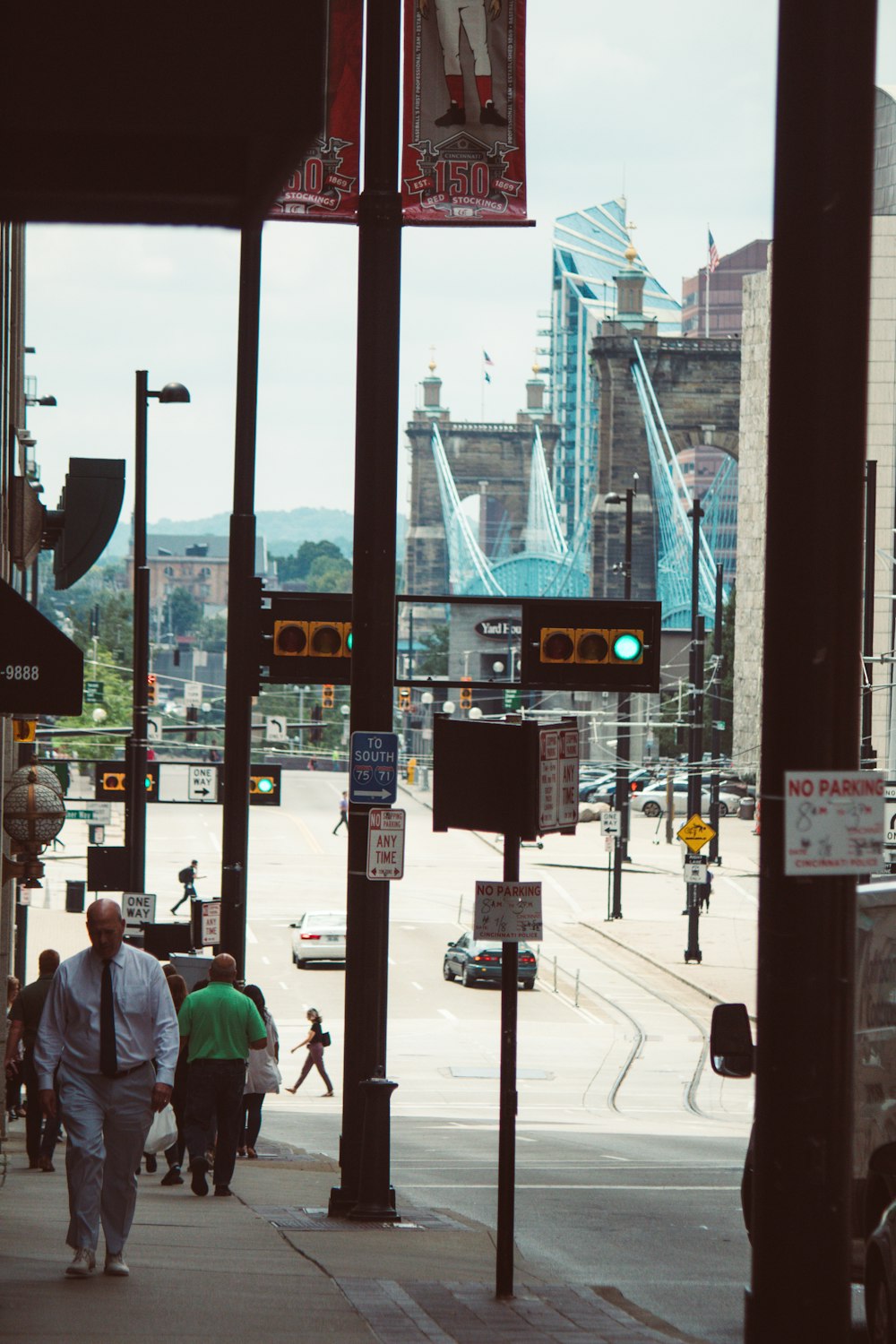 a group of people walking down a street next to a traffic light