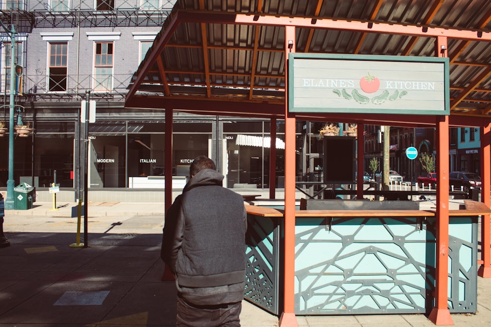 a man standing in front of a food stand