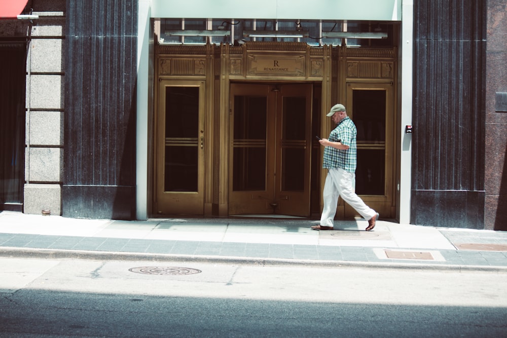a man walking down the street in front of a building