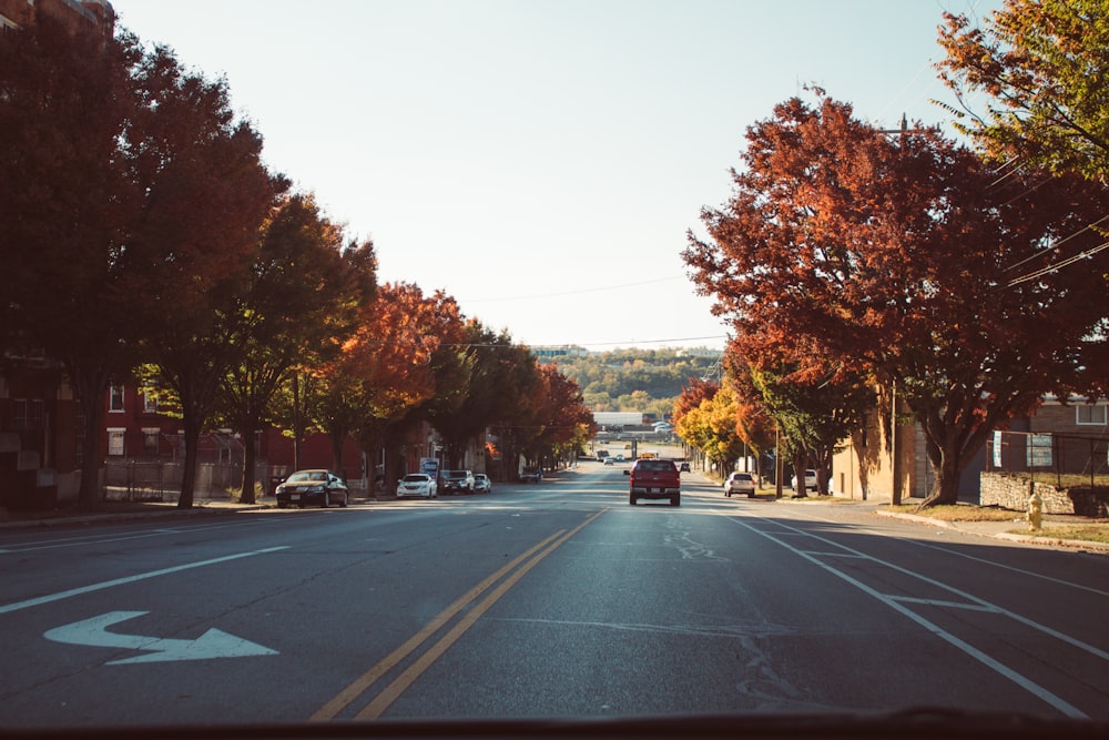 a car driving down a street next to trees