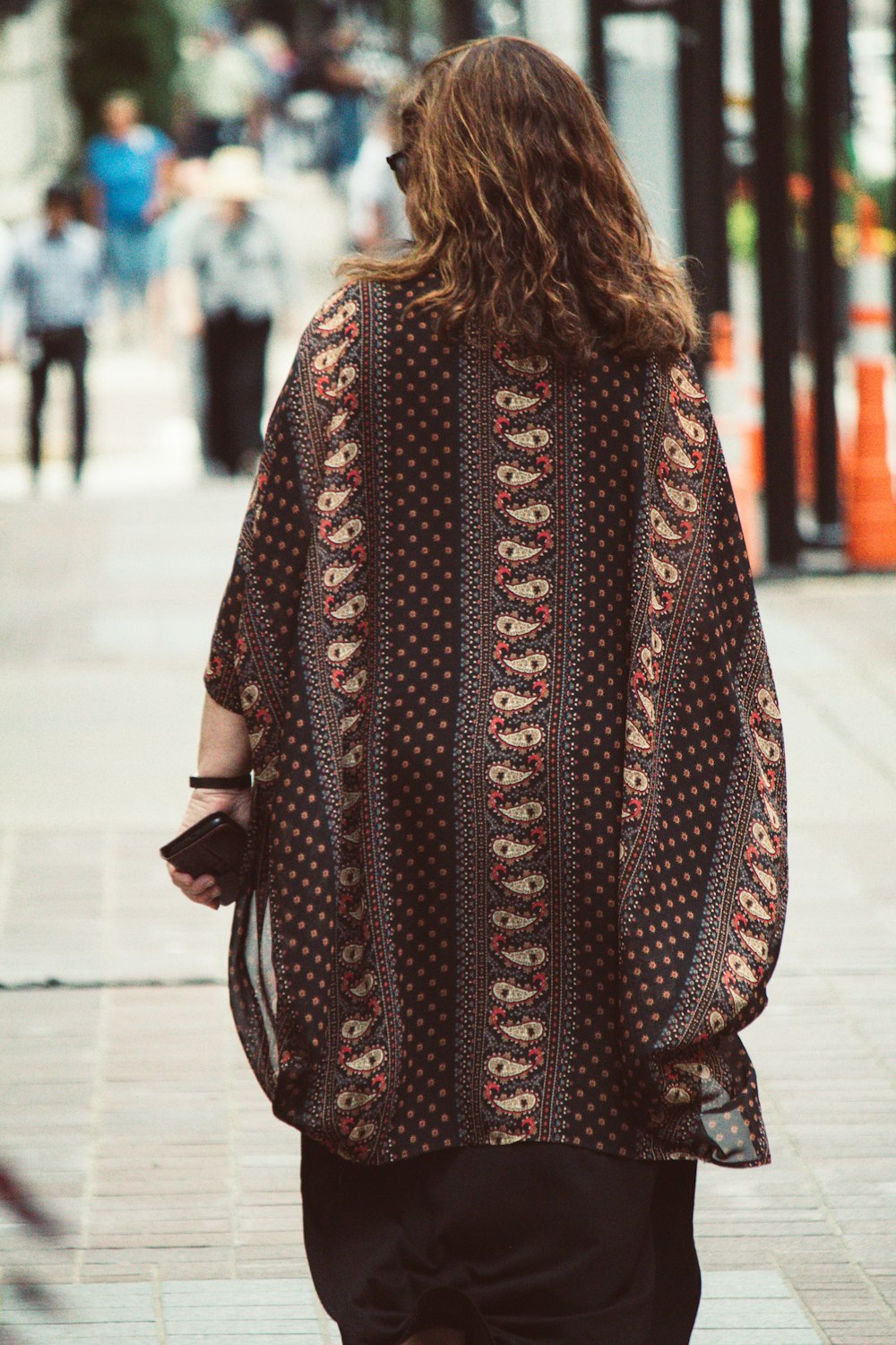 a person walking down a sidewalk with a jacket on