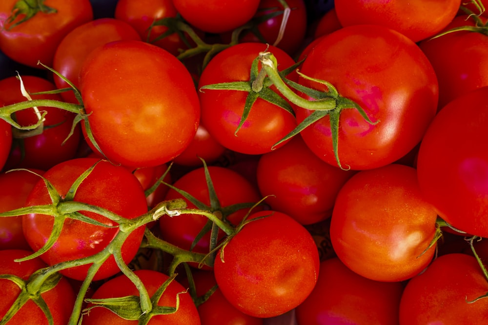 a pile of red tomatoes sitting on top of each other