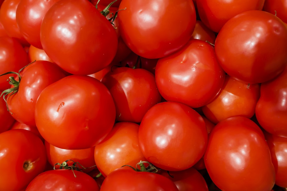 a pile of red tomatoes sitting on top of each other