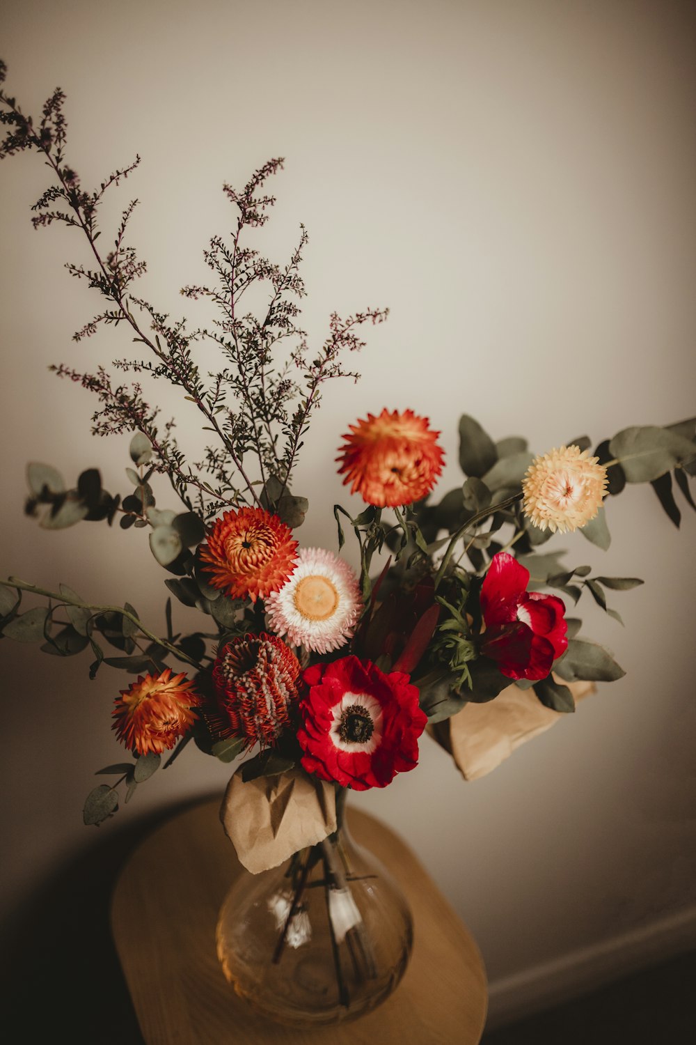 a vase filled with lots of flowers on top of a table