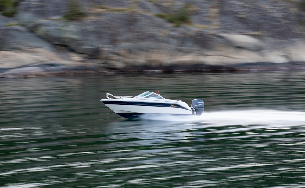 a speed boat speeding across a body of water