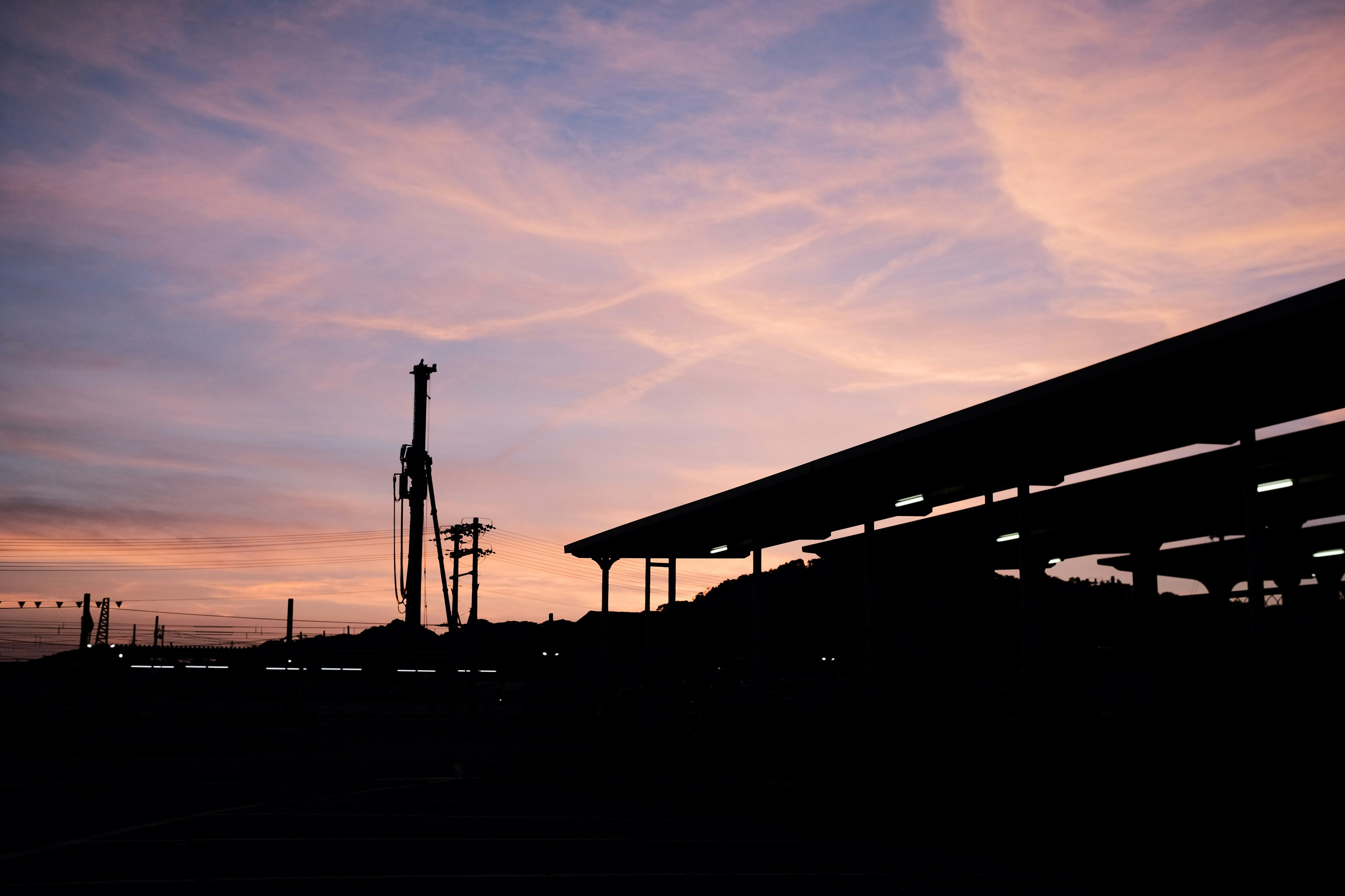 a silhouette of a gas station at sunset