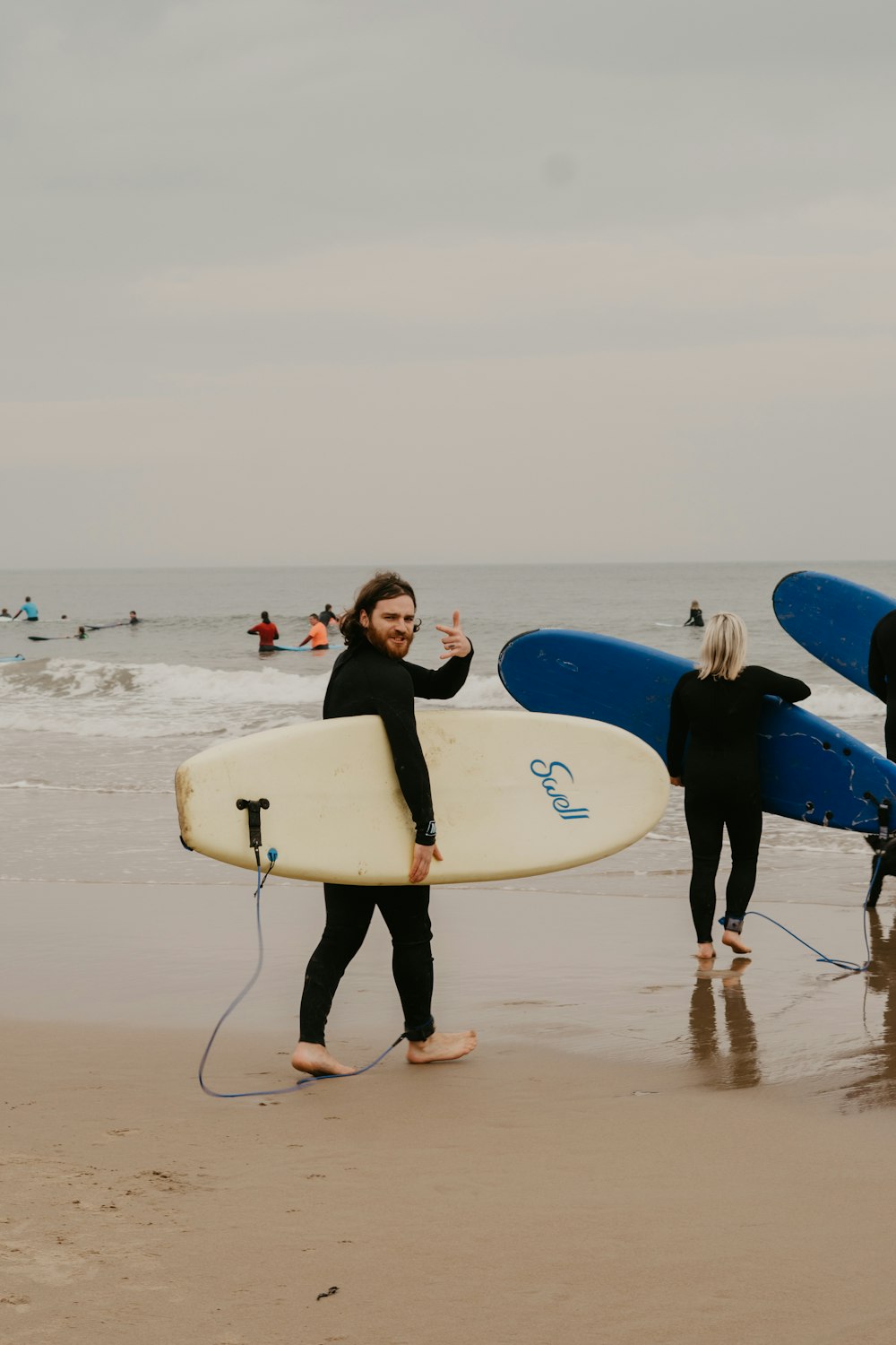 a couple of people holding surfboards on a beach