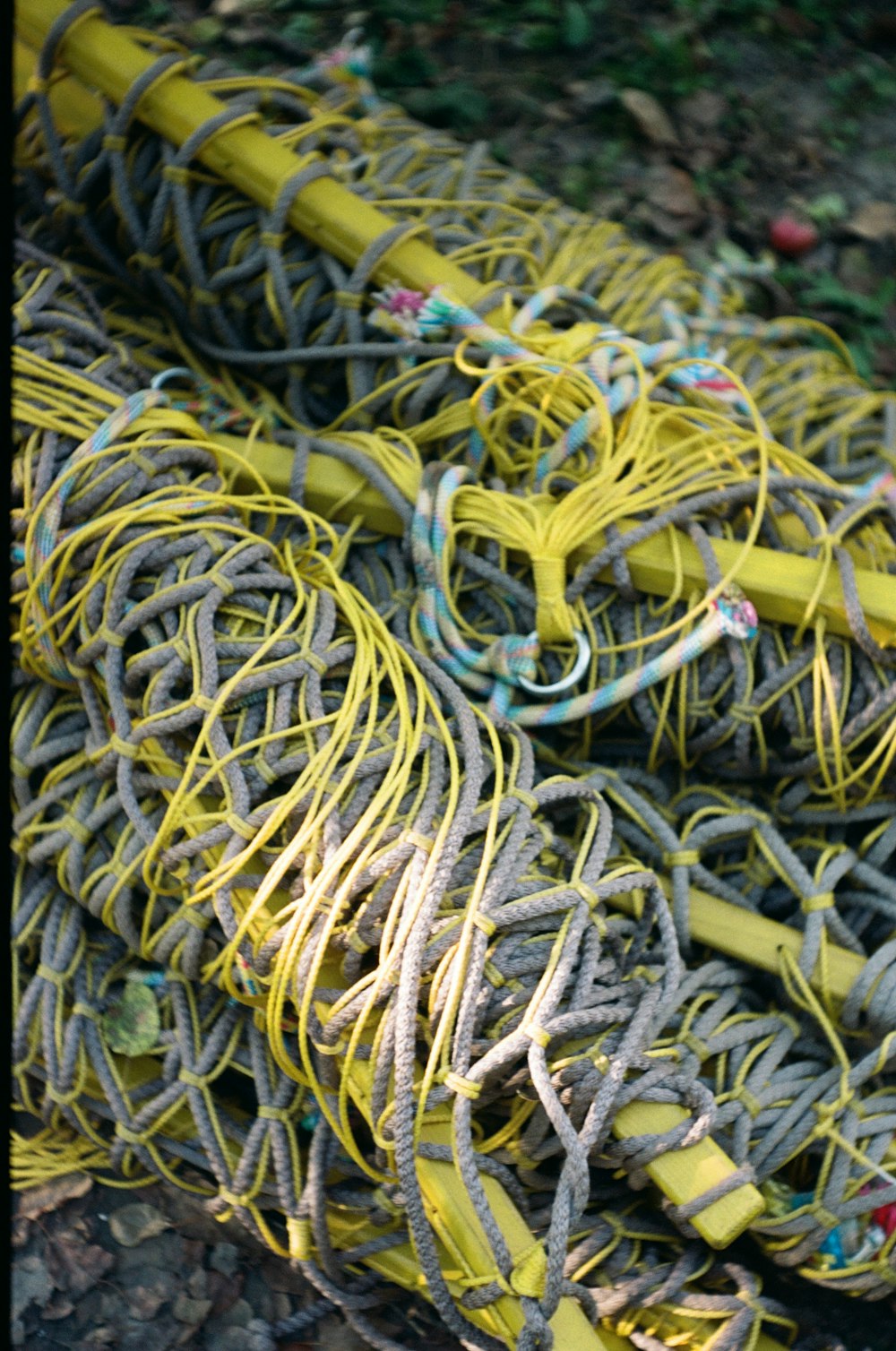 a pile of yellow and gray ropes on the ground