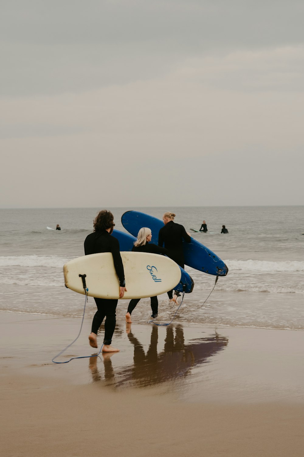 a couple of people holding surfboards on a beach