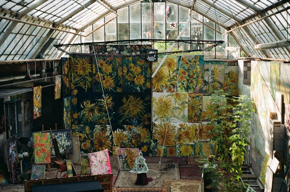 a room filled with lots of paintings and plants