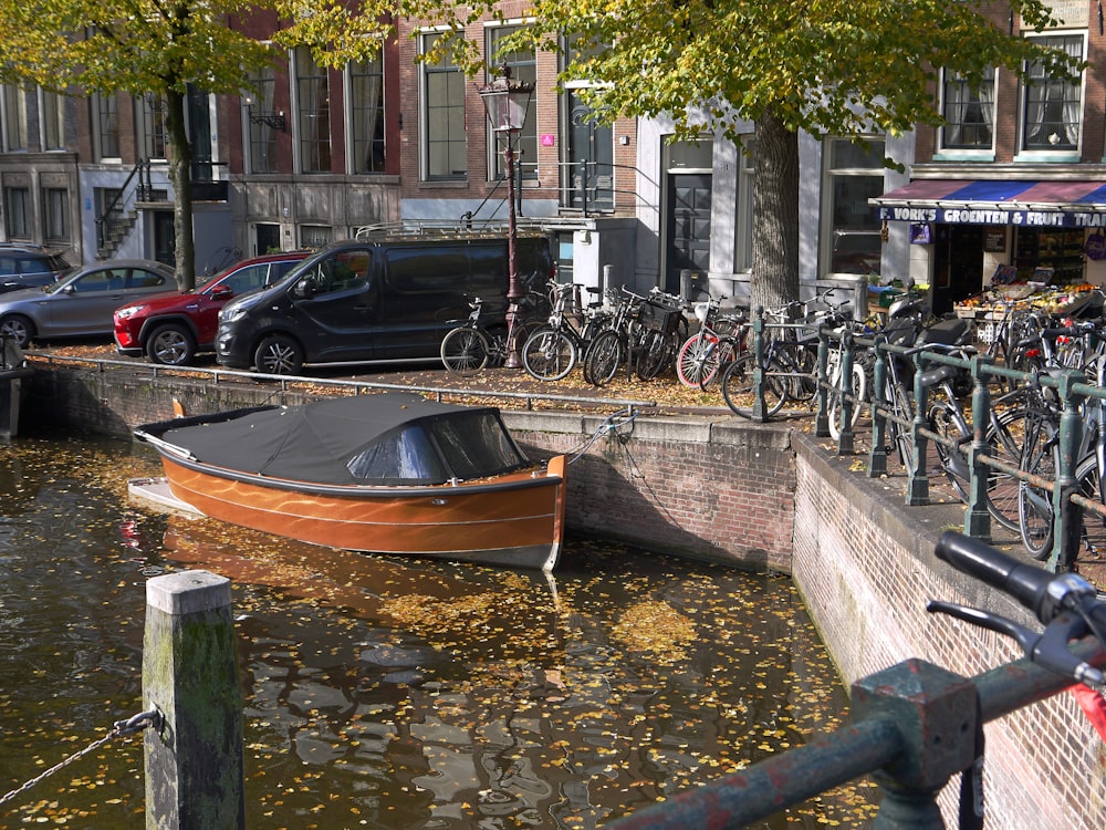 a boat in a body of water next to a row of parked bikes