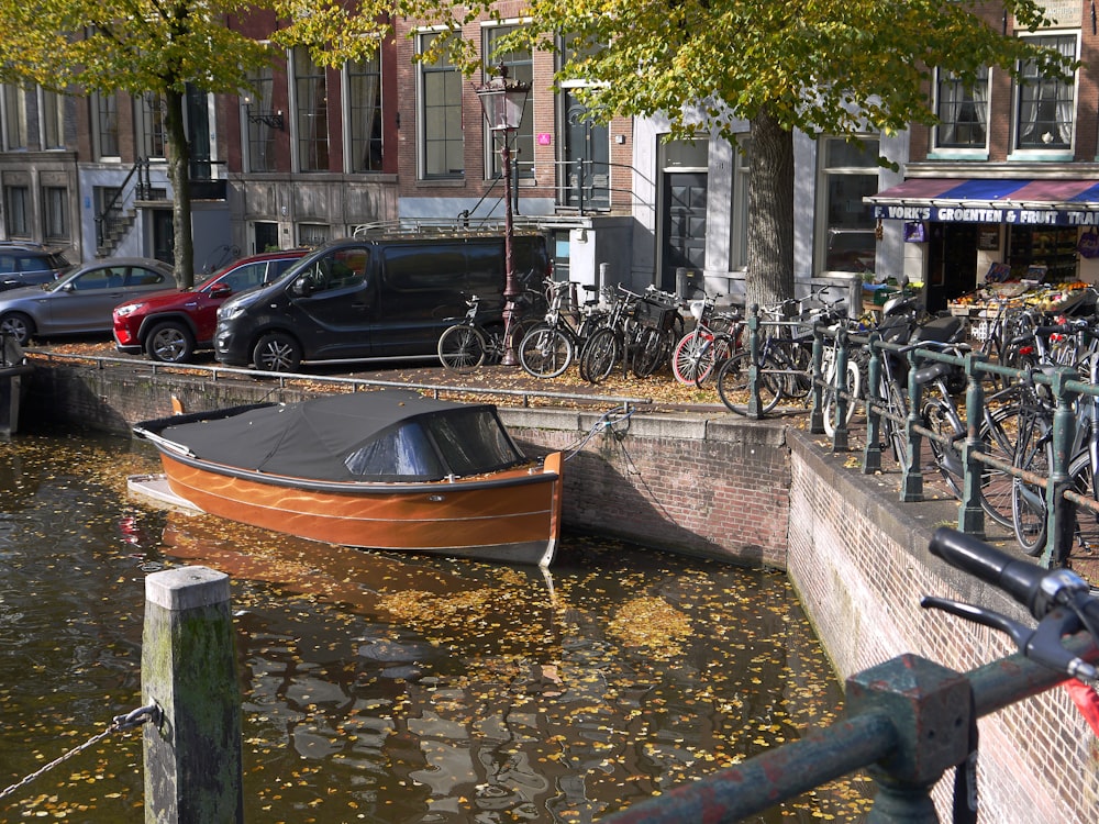 un bote en un cuerpo de agua junto a una fila de bicicletas estacionadas