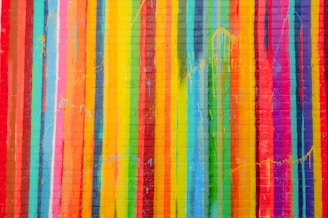 a multicolored brick wall with vertical lines painted on it
