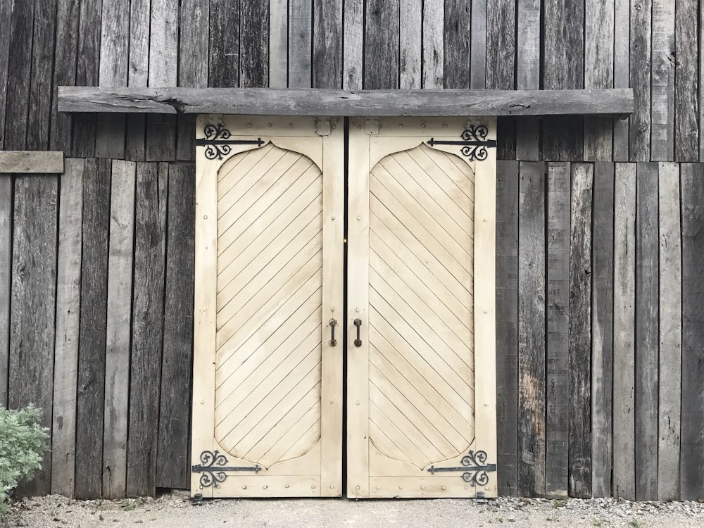 a couple of wooden doors sitting next to a building
