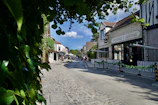 A serene view of a quiet village street lined with artisan shops and cozy cafés.