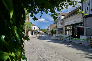 A serene view of a quiet village street lined with artisan shops and cozy cafés.