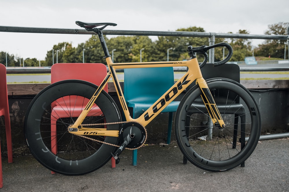 a yellow bike parked next to a red and blue chair