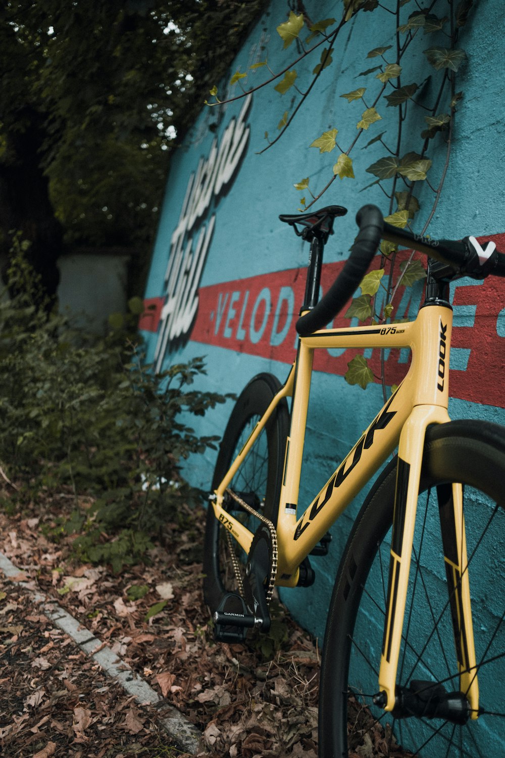 a yellow bike leaning against a blue wall