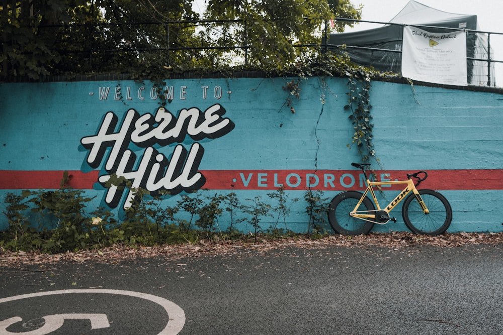 a bicycle parked in front of a blue wall