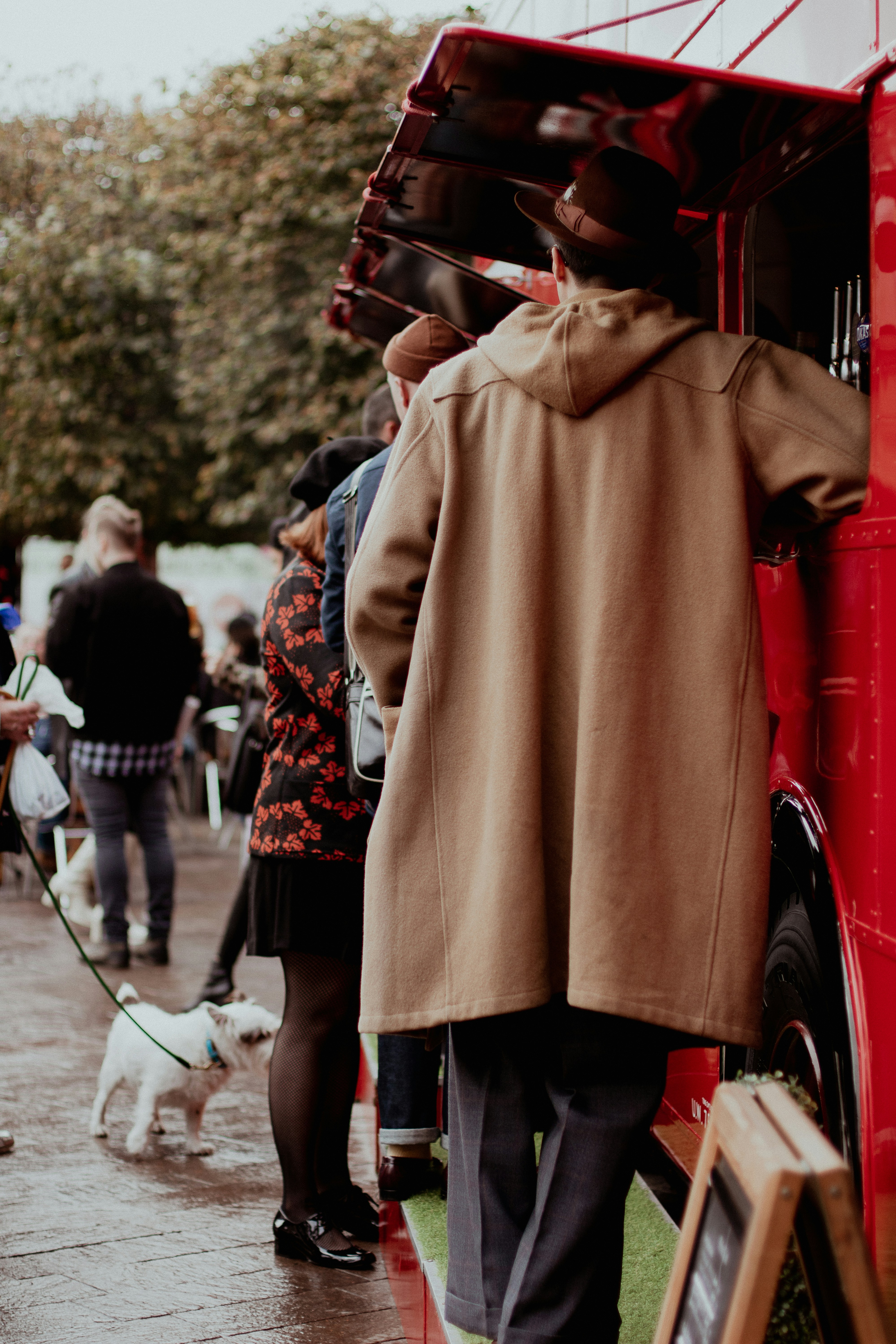 a man standing next to a red double decker bus