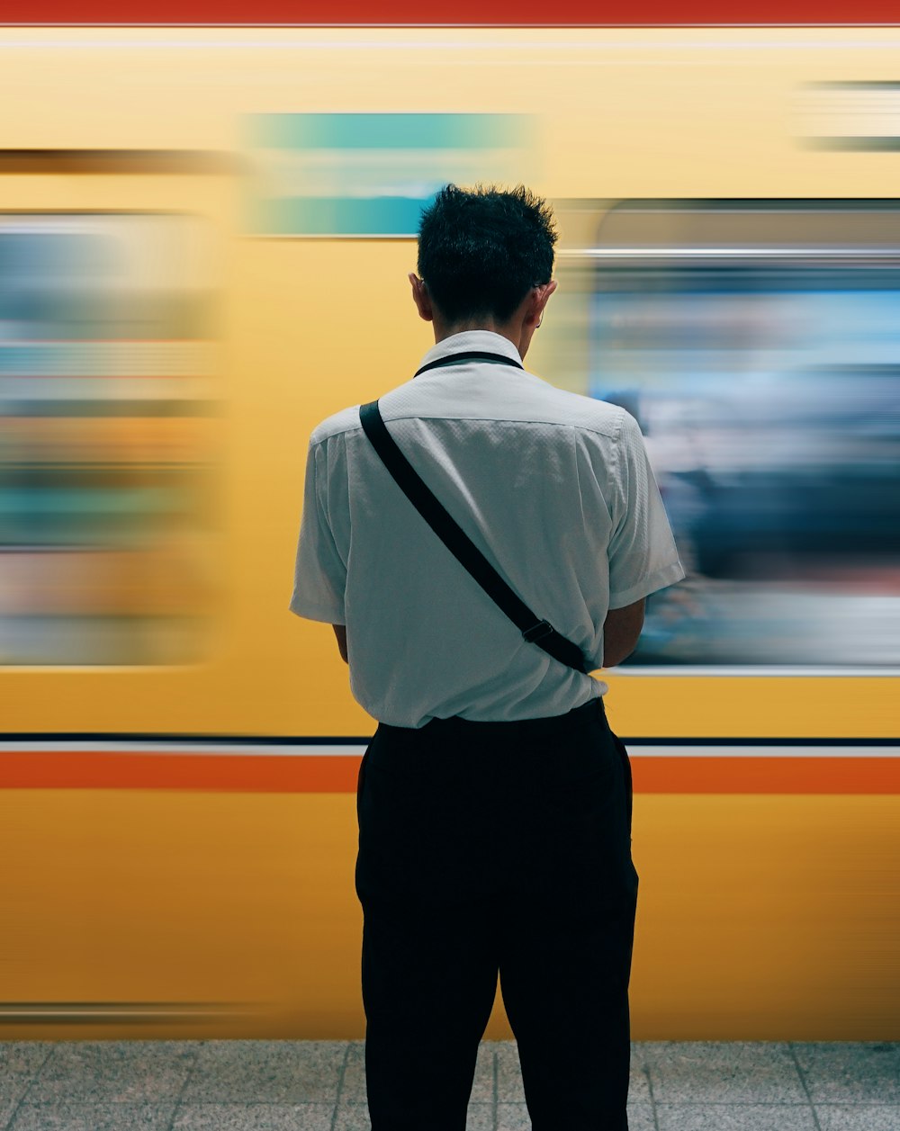 a man standing in front of a yellow train