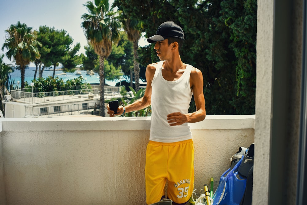 a man in yellow shorts and a white tank top