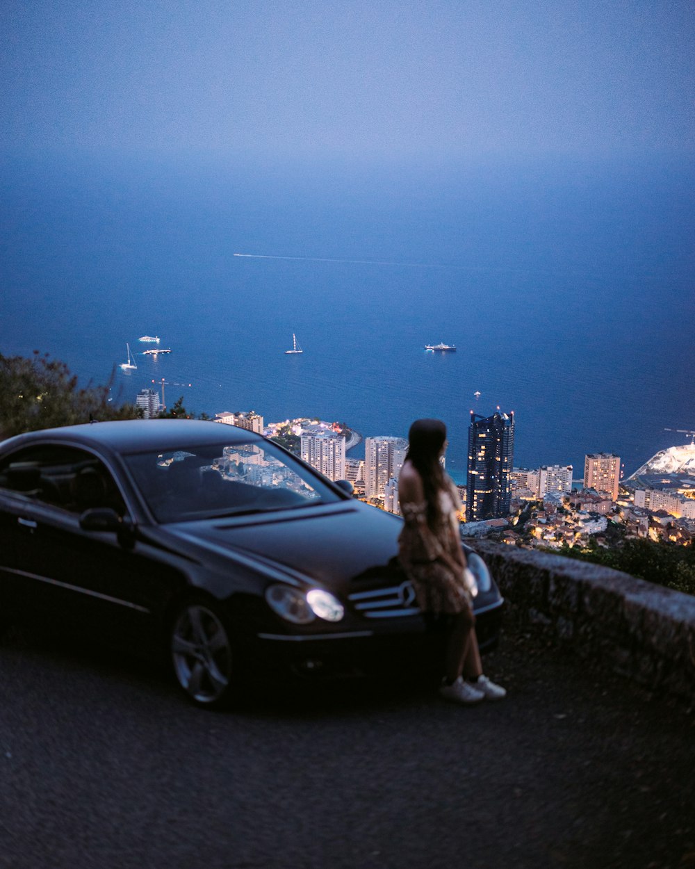 uma mulher em pé ao lado de um carro preto