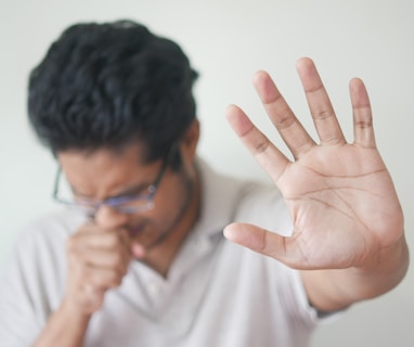 a man holding his hand up in front of his face