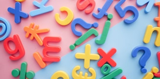 a pile of plastic letters and numbers on a pink and blue background