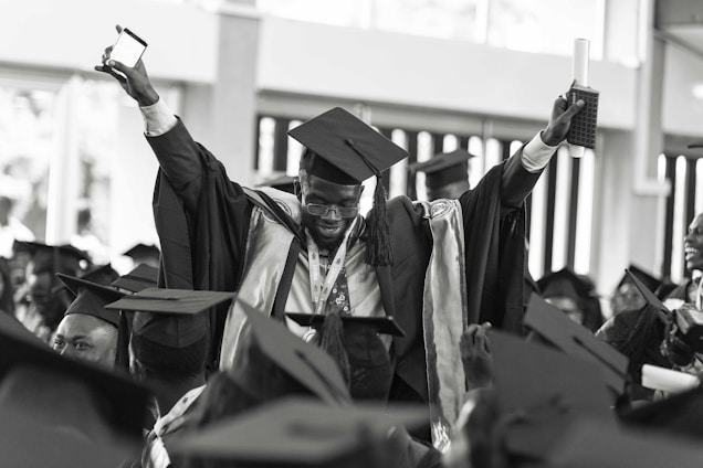 A joyful graduation celebration with students wearing elegant gowns and caps, capturing moments with cameras.