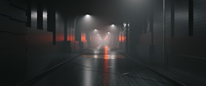 A dimly lit, foggy urban alley with street lamps casting light on wet pavement. The walls are textured with a modern industrial look, featuring vertical panels and subtle orange reflections.