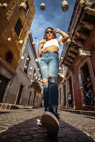 A casual, youthful person walking confidently wearing colorful espadrilles on a sunny street.