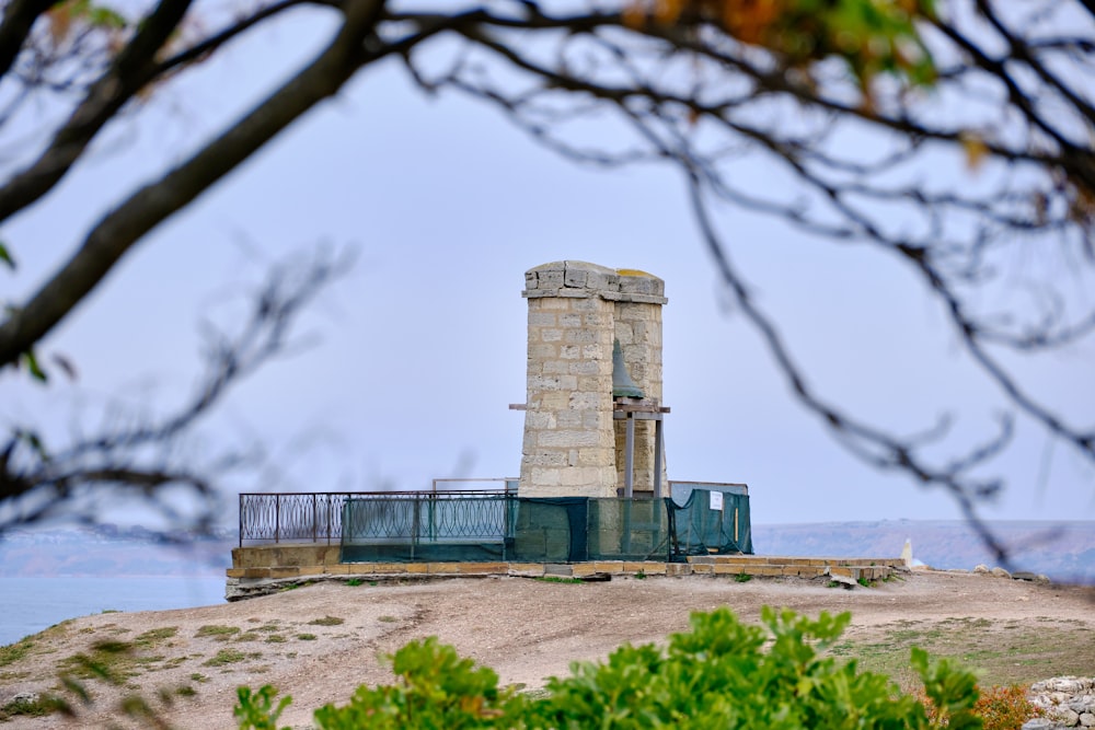 a tall tower sitting on top of a lush green hillside