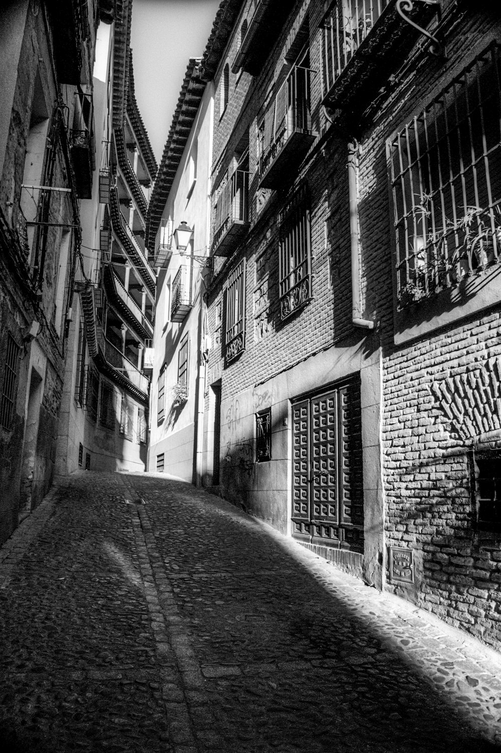 a black and white photo of a narrow street