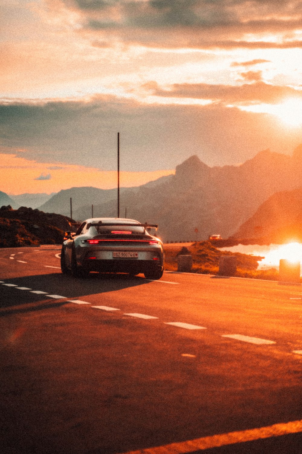 a car driving down a road at sunset