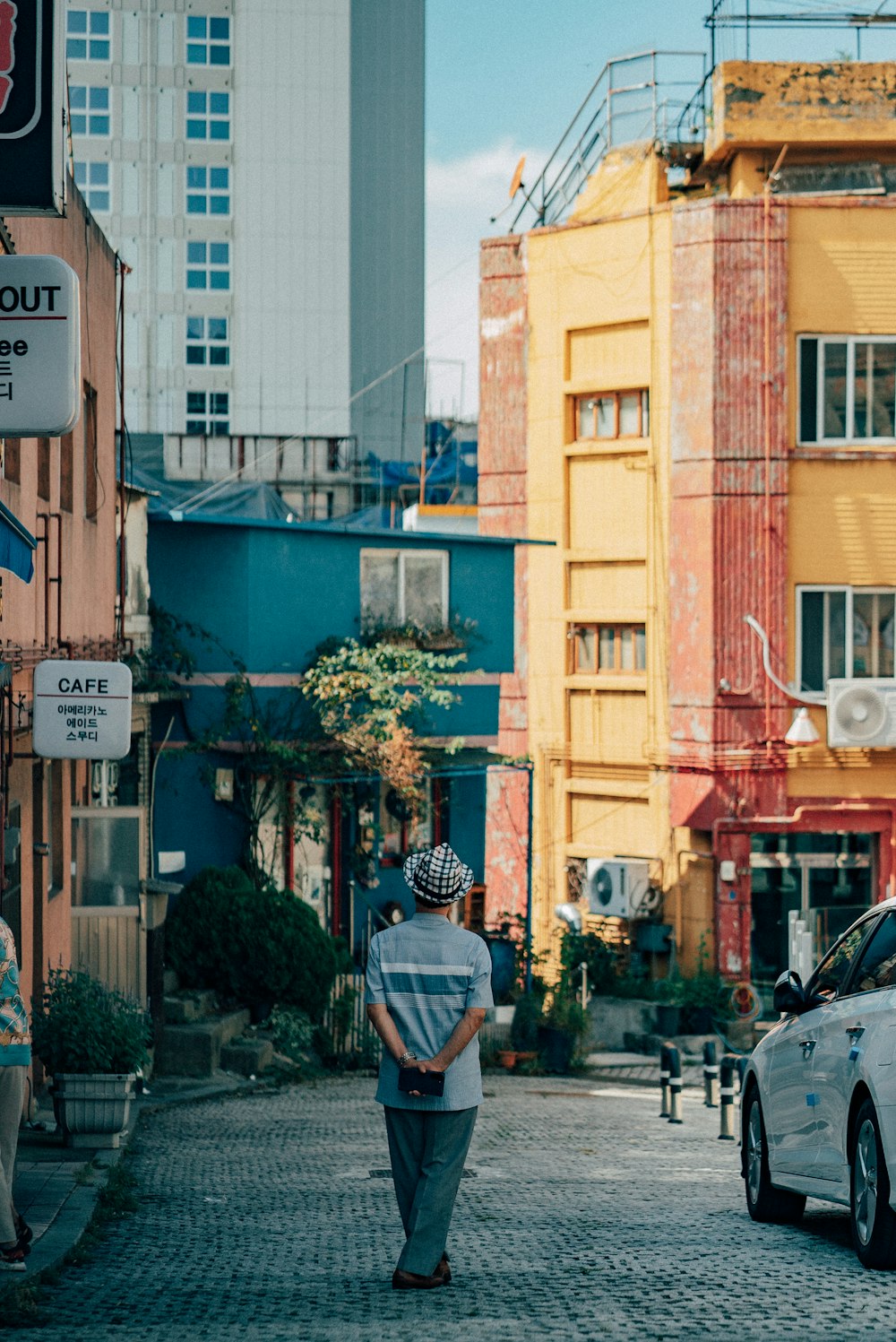 a man walking down a street next to tall buildings