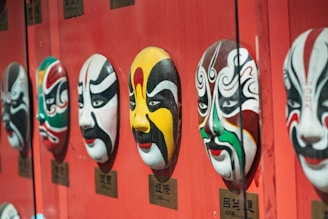 a row of masks on a red wall