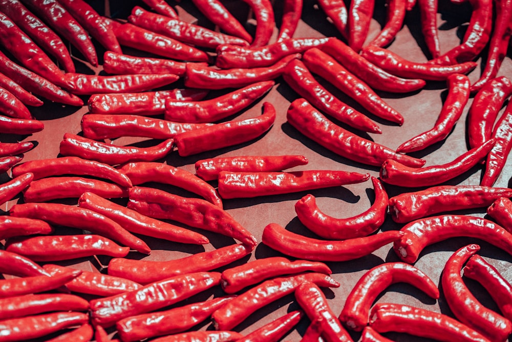 a pile of red hot peppers sitting on top of a table