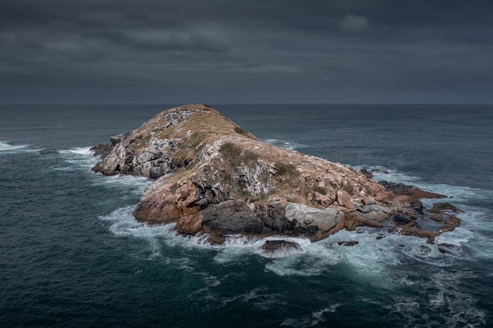 a large rock in the middle of the ocean