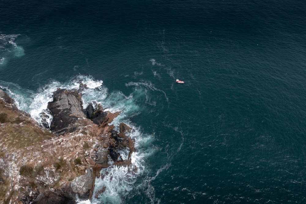 an aerial view of a body of water with a boat in it