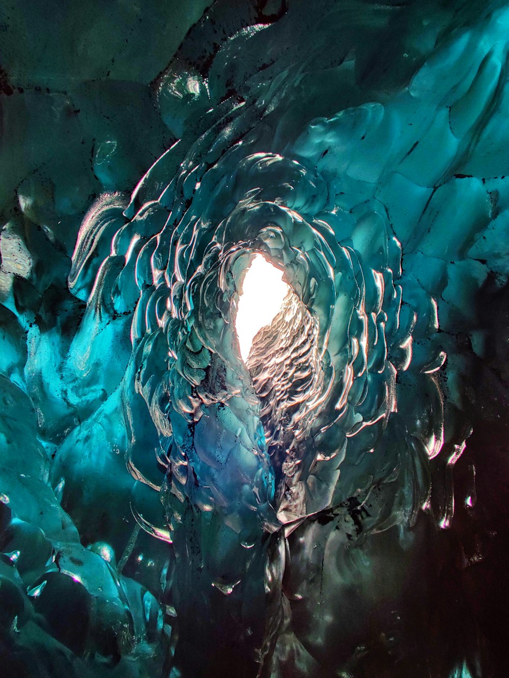 a large ice cave with a light coming out of it