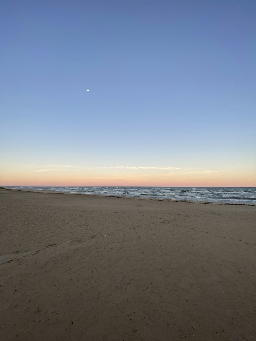 a person walking on a beach near the ocean