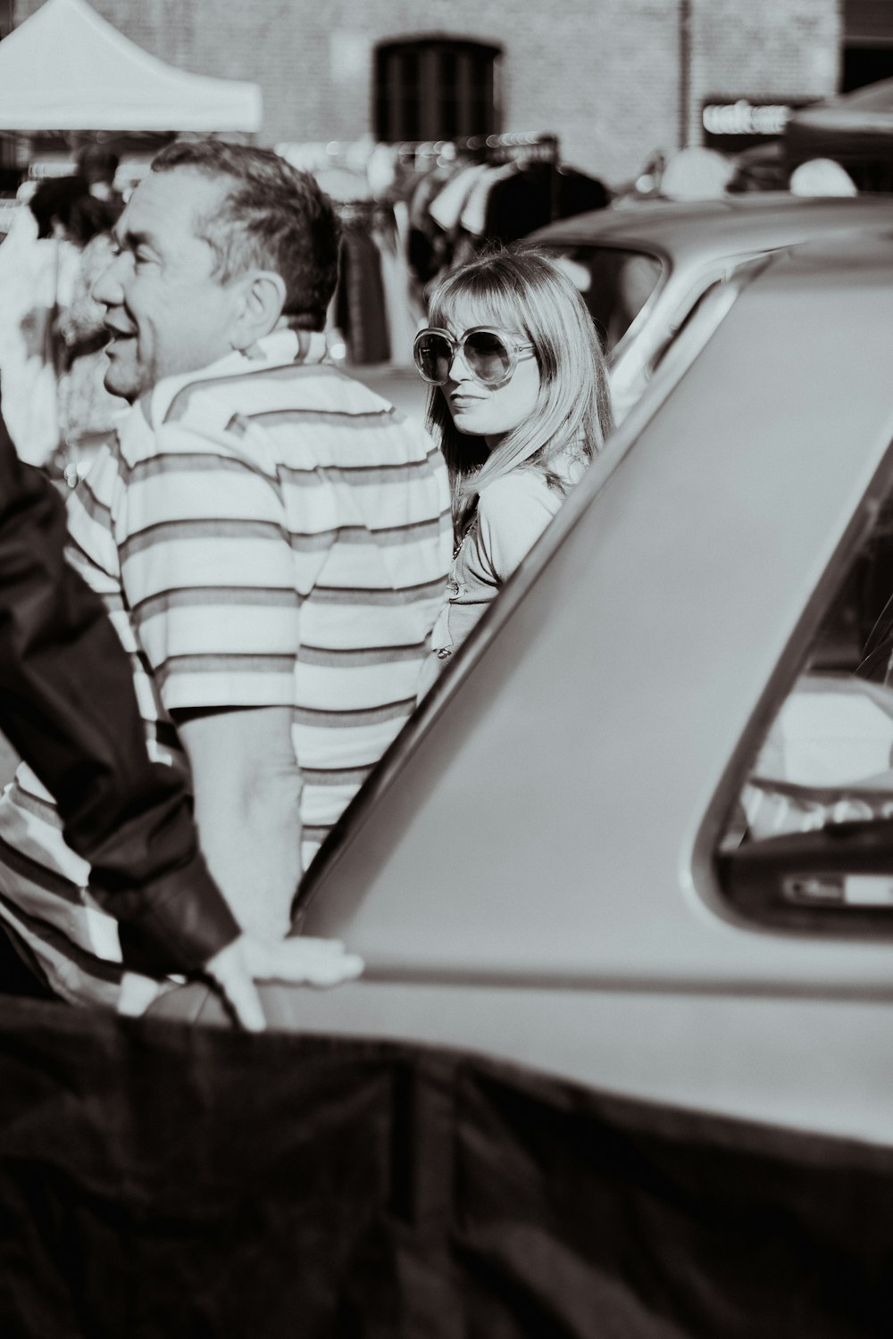 a man standing next to a woman in a car