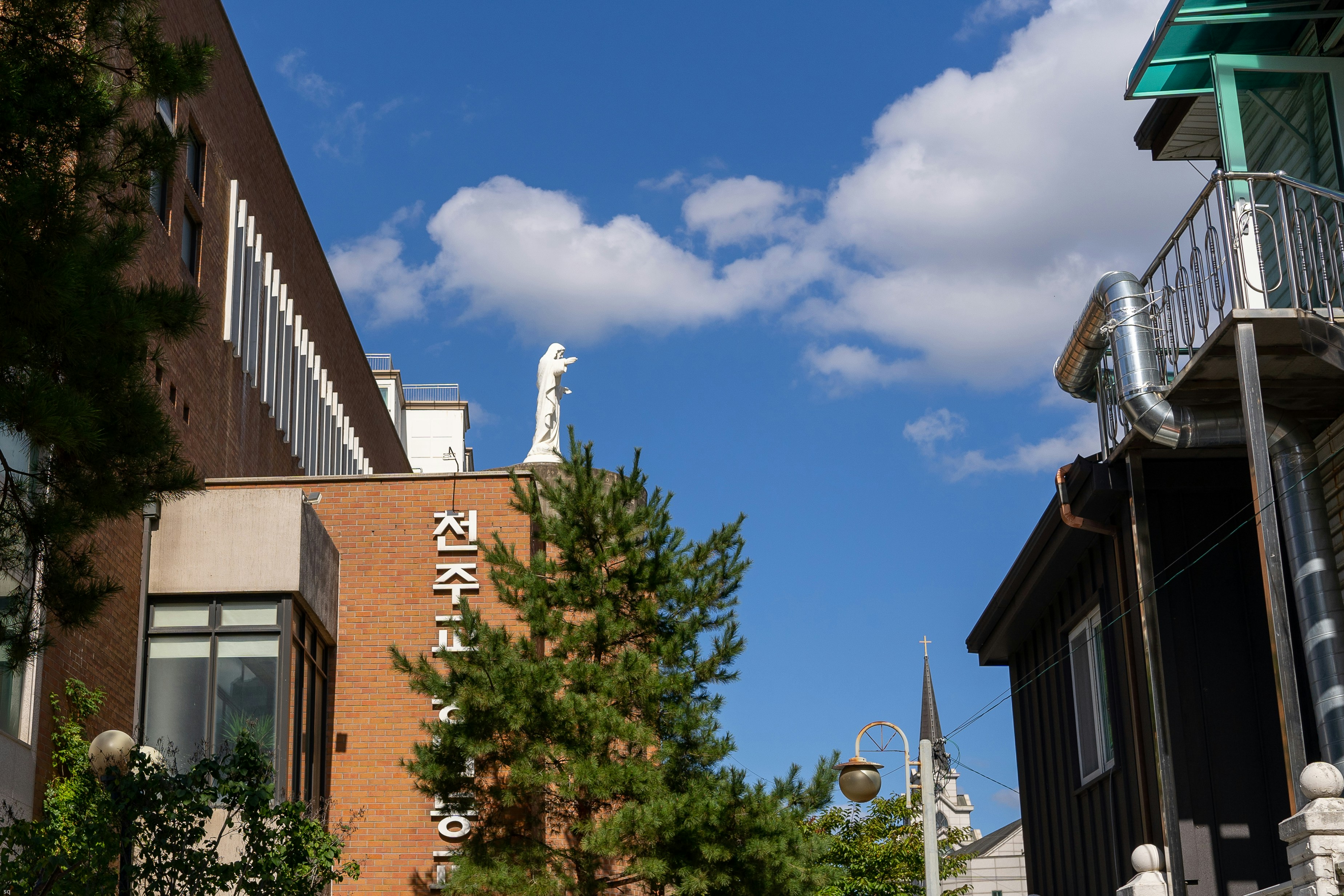 a tall brick building with a white statue on top of it