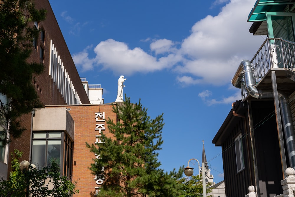 a tall brick building with a white statue on top of it