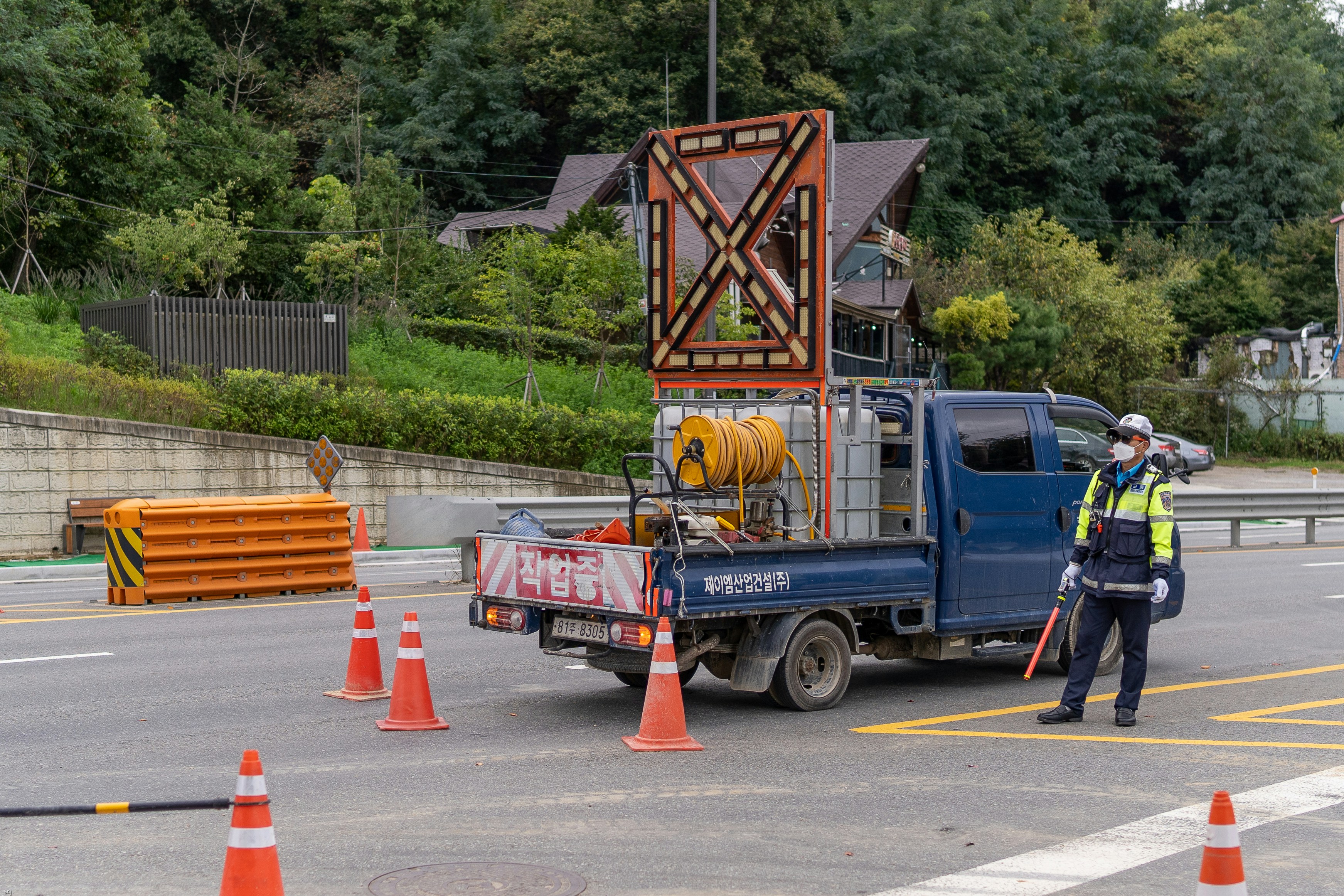 a man standing next to a blue truck on a road