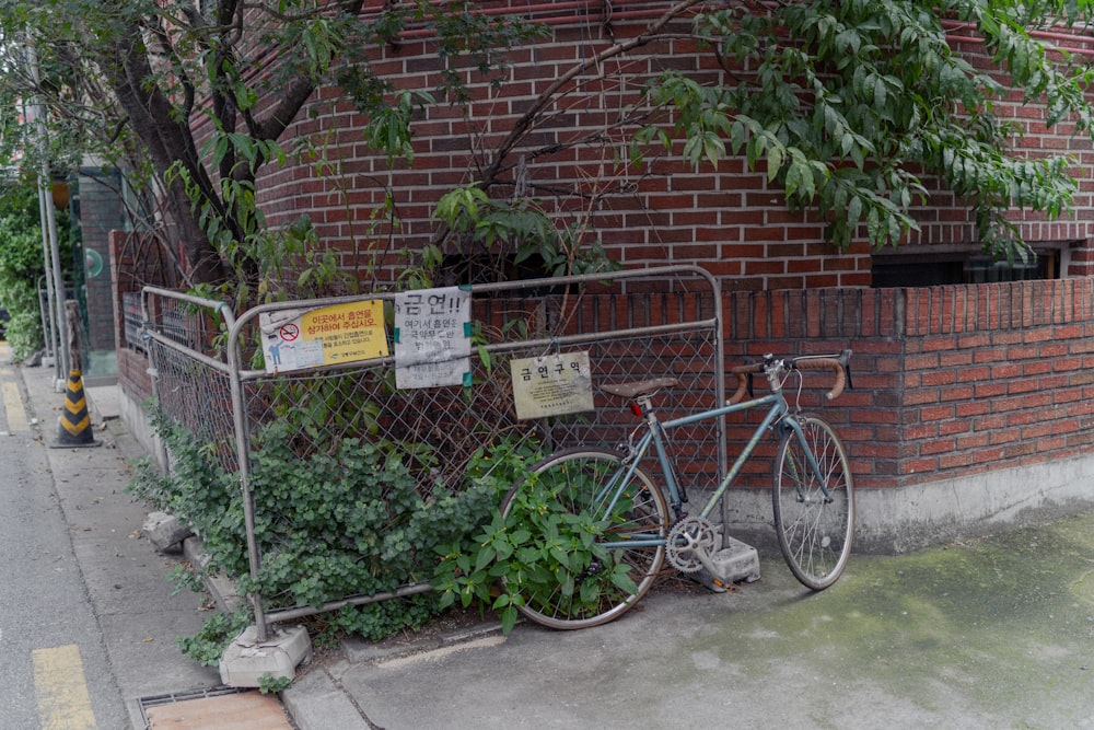 uma bicicleta encostada a uma cerca ao lado de um edifício