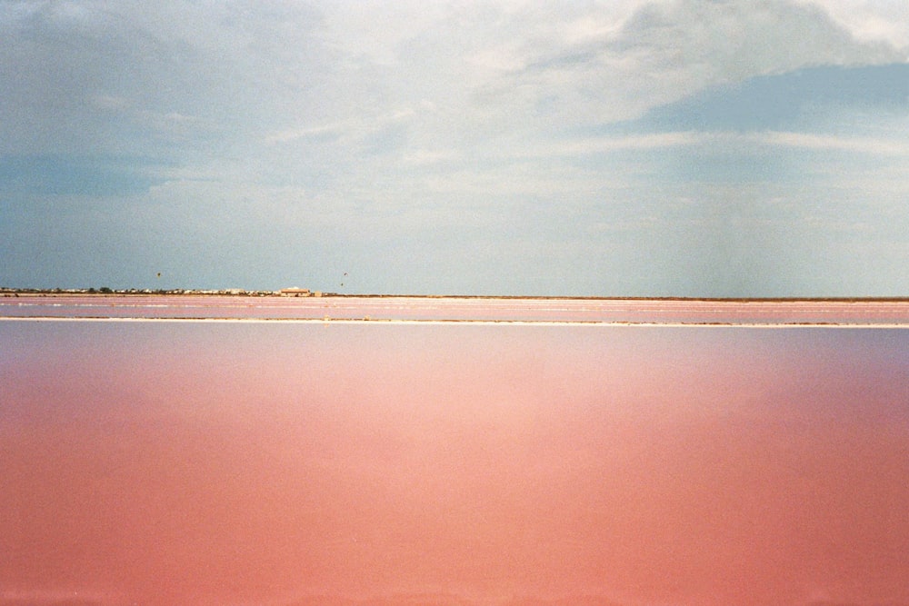 a large body of water with a sky in the background