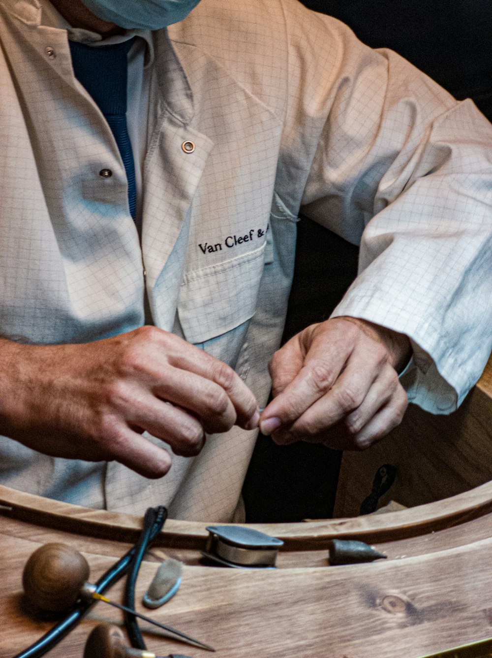 a man in a white shirt and a mask working on a piece of wood